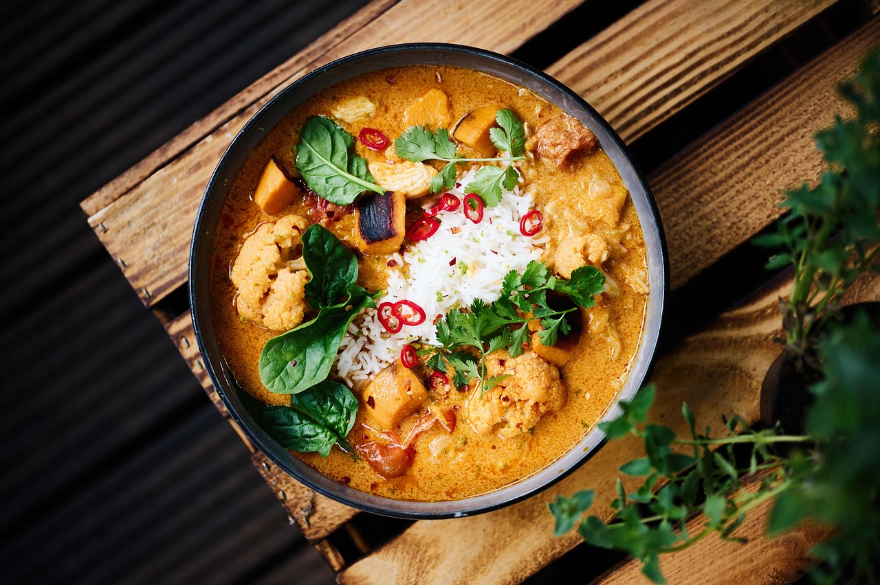 A bowl of curry with vegetables and meat